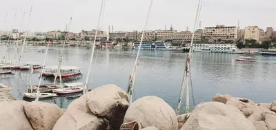 a marina with boats in the water and buildings at Mostafa Jamaica guesthouse in Aswan