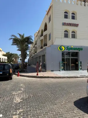a building on a street in front of a store at Apartment with private Beach in Sahl Hasheesh in Hurghada