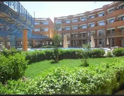 a large building with a green yard in front of it at Oasis resort-Nice Condo -B31-Al Ahyaa - Hurghada in Hurghada