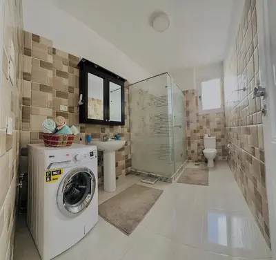 a bathroom with a washing machine and a sink at Luxor Rose Villa in Luxor