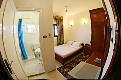 a small room with a bed and a bathroom at Luxor Hotel Hurghada in Hurghada