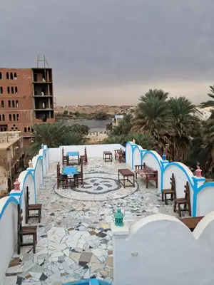 a patio with chairs and tables on a stone floor at Lawanda Nubian B&B in Aswan