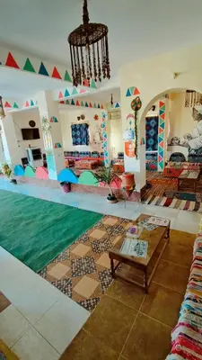 a living room with a swimming pool and a table at Lawanda Nubian B&B in Aswan