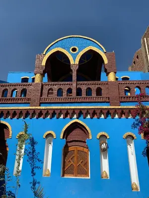 a blue building with a brown door and windows at Golden palace Nile view - Appartment in Luxor