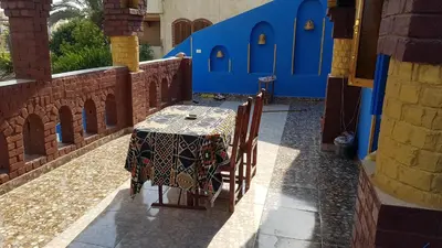 a table and chairs in a patio with blue walls at Golden palace Nile view - Appartment in Luxor