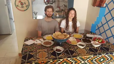 a man and a woman sitting at a table with food at Golden palace Nile view - Appartment in Luxor