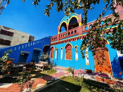 a blue building with orange doors and windows at Golden palace Nile view - Appartment in Luxor