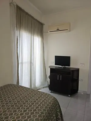 a bedroom with a bed and a dresser with a television at Hurghada Village sea view in Hurghada