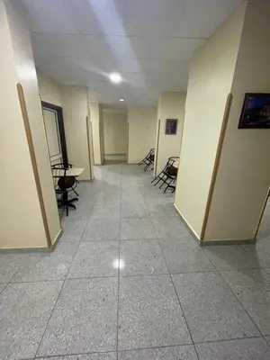 an empty hallway with chairs and tables in a building at Makkah Hotel in Qena