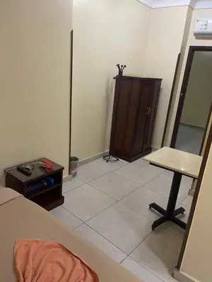 a room with a table and a cabinet in it at Makkah Hotel in Qena