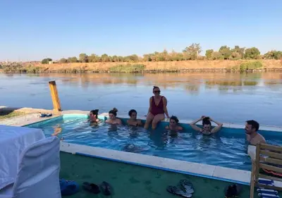 a group of people in a swimming pool on the river at Fenti Nubian Resort in Aswan