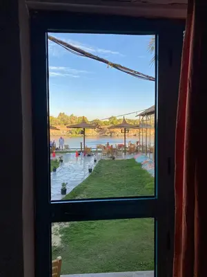 a window view of a swimming pool from a house at Fenti Nubian Resort in Aswan