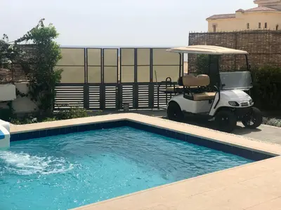 a golf cart parked next to a swimming pool at Villa KUBA luxury private pool 2 in Hurghada