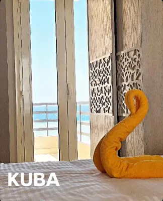 a bed with an orange towel on it with a view of the ocean at Villa KUBA luxury private pool 2 in Hurghada