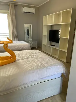 a bedroom with two beds and a flat screen tv at Villa KUBA luxury private pool 2 in Hurghada