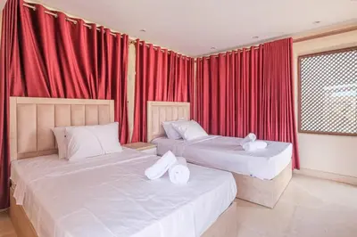 two beds in a room with red curtains at El Gouna abo tig marina 1 bedroom apartment and 1 bedroom at the Roof in Hurghada