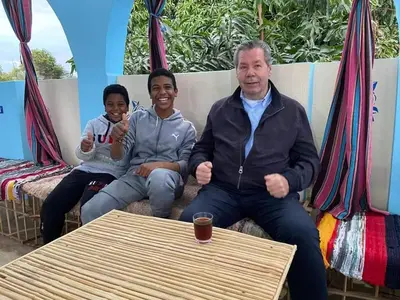 two men and a child sitting on a bench with a table at Nubia castle in Aswan