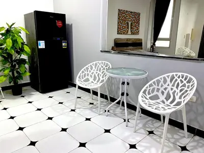 two white chairs and a table in a kitchen at Lima Modern. Sea View. Strong Wi Fi. Sheraton Road in Hurghada