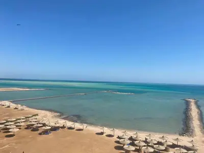 an empty beach with umbrellas and the ocean at Tertels beach resort hurghada F 2-6 in Hurghada