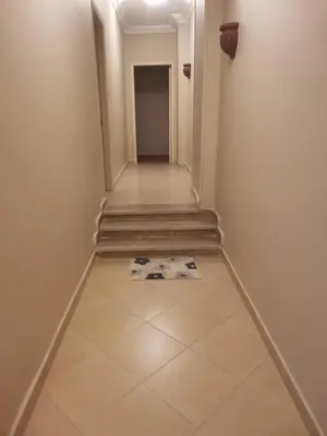 a hallway with stairs and a tiled floor at Marvel flat in Hurghada