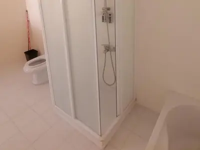 a white bathroom with a shower and a toilet at Marvel flat in Hurghada