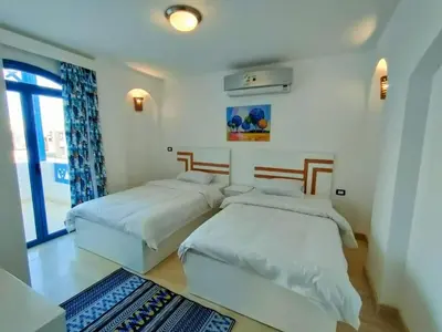 a bedroom with two beds and a window at Amaros Sahl Hasheesh sea view Villa with Pool سهل حشيش in Hurghada