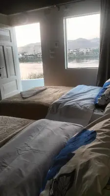 two beds in a room with a window at Go Inn Backpackers in Aswan