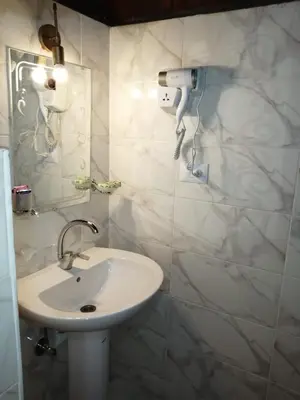 a white bathroom with a sink and a mirror at Go Inn Backpackers in Aswan