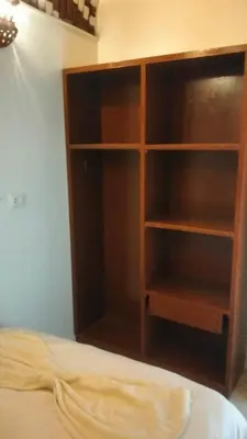 a wooden book shelf next to a bed at Go Inn Backpackers in Aswan