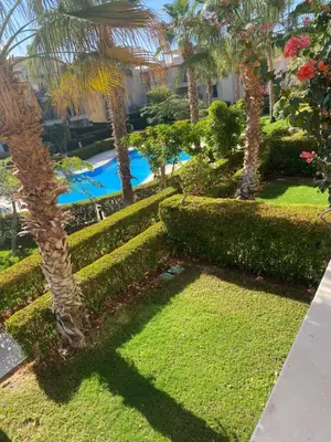a resort yard with a swimming pool and palm trees at A studio in Veranda Sahl Hasheesh in Hurghada