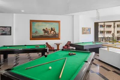 a billiard room with two pool tables and a painting at Beach Albatros The Club - Aqua Park in Hurghada