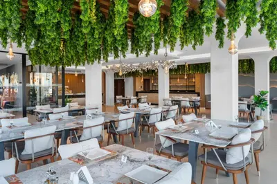 a restaurant with tables and chairs and vines at Beach Albatros The Club - Aqua Park in Hurghada