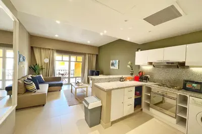 a kitchen and living room with a couch and a table at Minimal & Central 1BDR Apt Abu Tig Marina in Hurghada