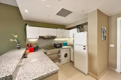 a kitchen with a white refrigerator and a dishwasher at Minimal & Central 1BDR Apt Abu Tig Marina in Hurghada