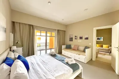 a bedroom with a large bed and a couch at Minimal & Central 1BDR Apt Abu Tig Marina in Hurghada