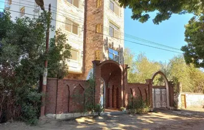 an old brick building with a gate in front of it at Embrace Guest House in Luxor