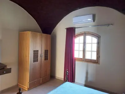 a room with a window and a door and a curtain at Embrace Guest House in Luxor