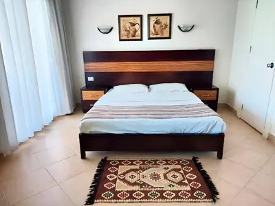 a bedroom with a large bed and a rug at JWE Residence - Quality experience near Red Sea in Hurghada