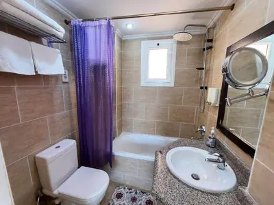 a bathroom with a toilet and a sink and a tub at JWE Residence - Quality experience near Red Sea in Hurghada