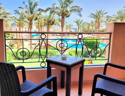 a table and chairs on a balcony with a view of a pool at JWE Residence - Quality experience near Red Sea in Hurghada