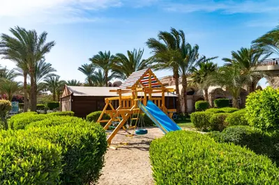 a playground with a slide in a garden at Utopia Beach Club in Marsa Alam City