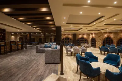 a lobby with tables and chairs and a bar at Utopia Beach Club in Marsa Alam City