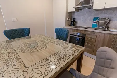 a kitchen with a wooden table and blue chairs at Babel Apartments Hotel El Gouna in Hurghada