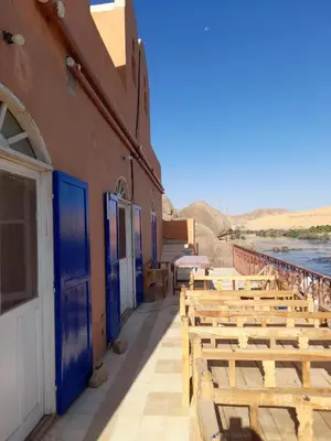 a row of wooden benches outside of a building at Belle Vue Sur Le Nile بيت هاني in Aswan
