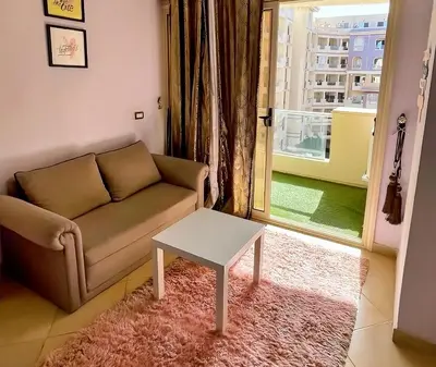 a living room with a couch and a table at Florenza Blue Sky & Poolview Studio Hurghada in Hurghada