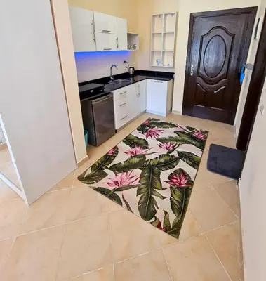 a kitchen with a rug on the floor at Florenza Blue Sky & Poolview Studio Hurghada in Hurghada