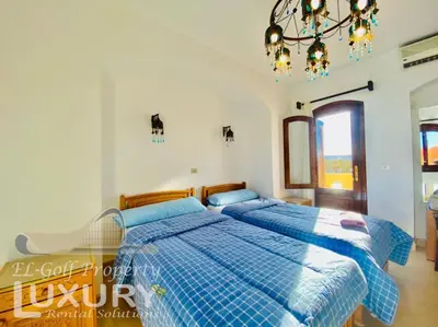 two beds in a bedroom with a chandelier at Private Villa Y51 - 3 BedRooms at El-Gouna in Hurghada