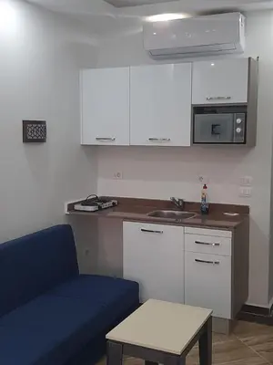 a kitchen with a blue couch and a table and a sink at Cecilia Resort Chalets- Hurghada in Hurghada