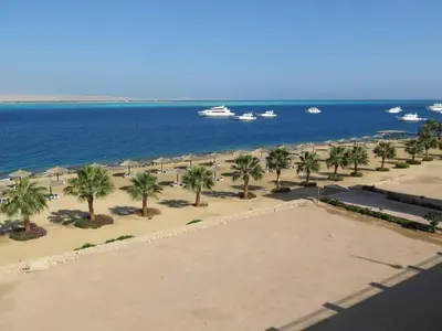 a view of a beach with palm trees and a boat at The view studio in Hurghada