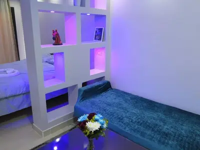 a room with a bed and a shelf with flowers at The view studio in Hurghada